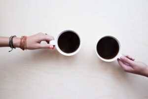 Duas mãos segurando xícaras de café