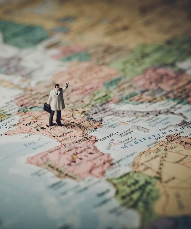 Miniature businessman on map of Europe. Color tone tuned